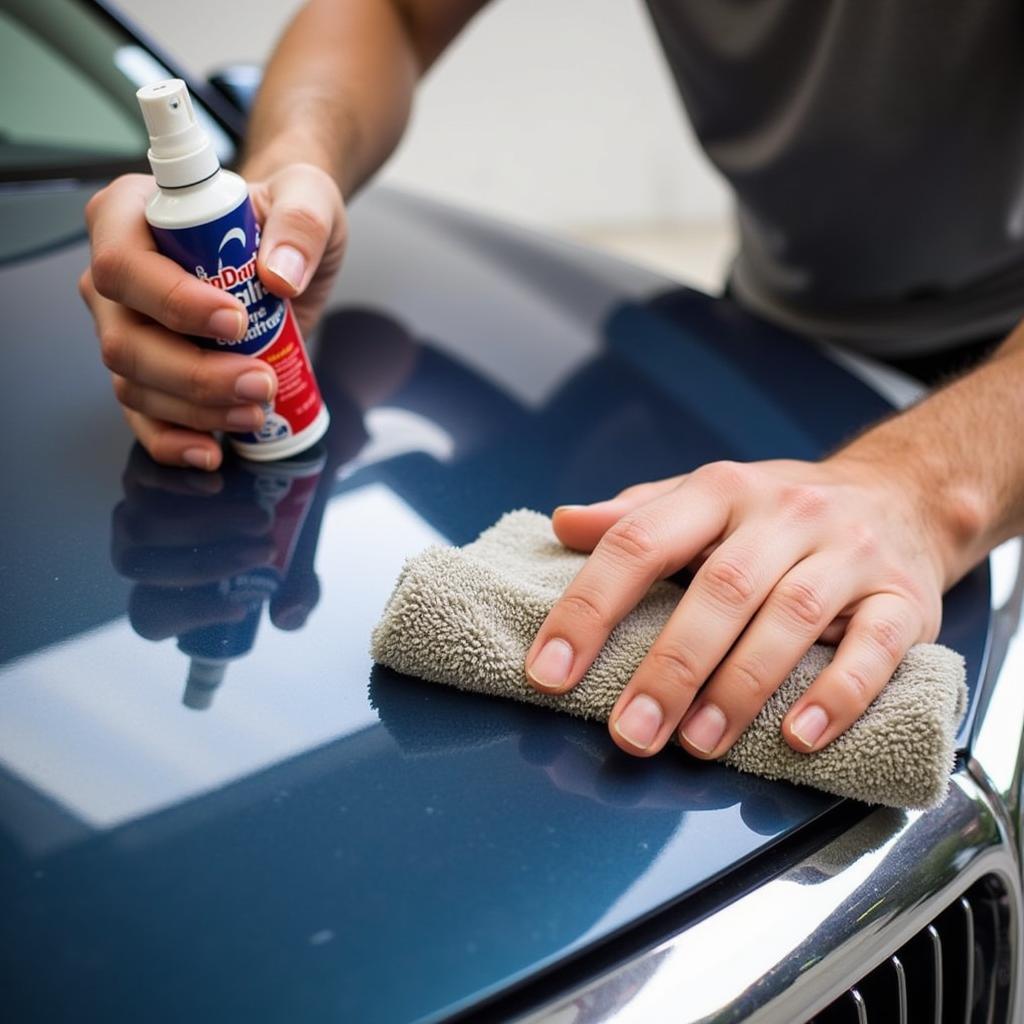 A person applying car detail spray using a microfiber cloth