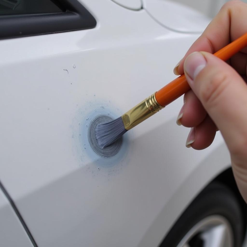 Applying touch-up paint to a car scratch using a fine-tipped brush