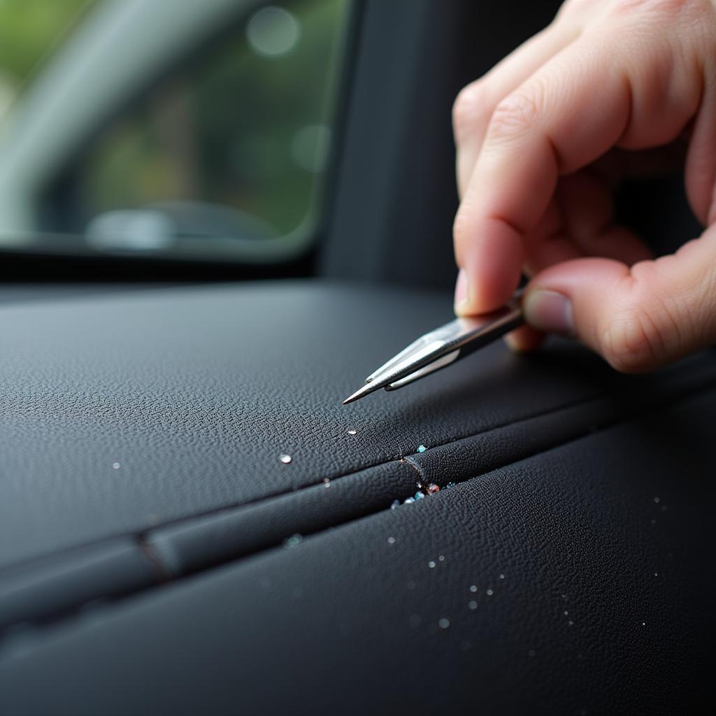 Car detailer meticulously removing tiny glass shards with tweezers