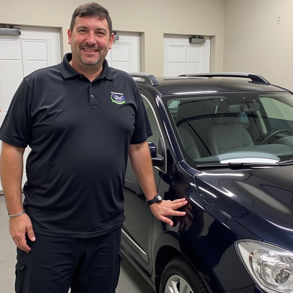 A satisfied customer standing next to their newly detailed car