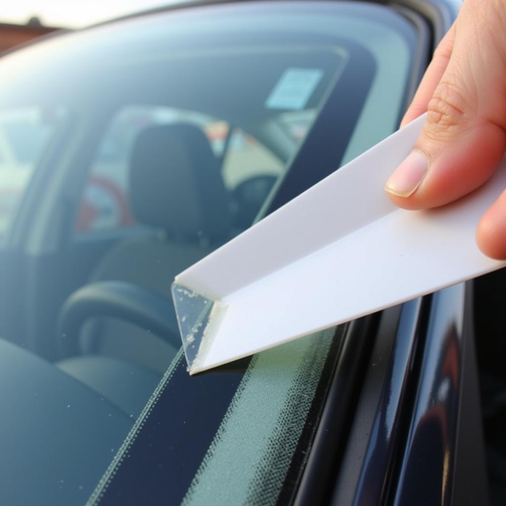 Using plastic razor blade to remove adhesive