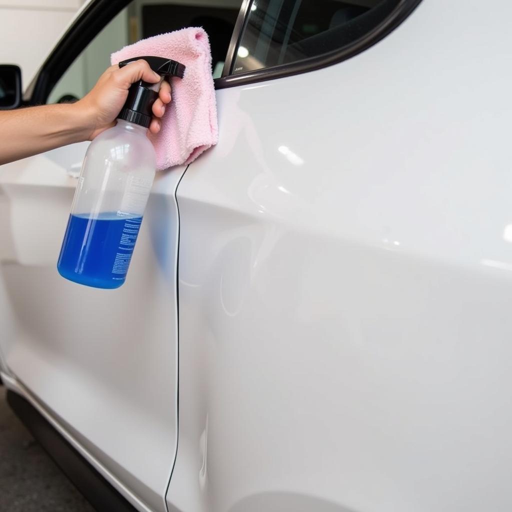 Applying spray detailer to a white car