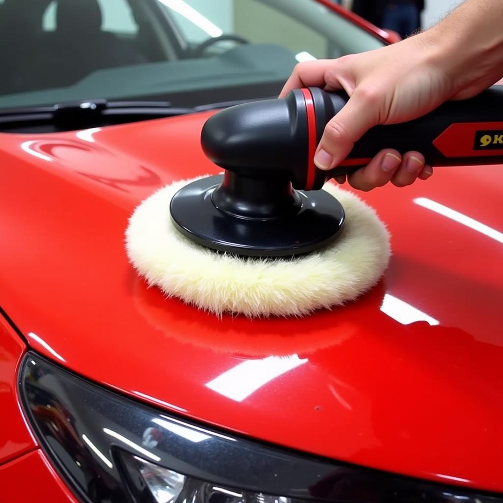 Electric Polisher Used for Car Detailing on a Red Car Hood