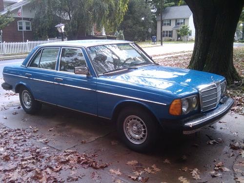 Front quarter view of a blue 1983 Mercedes-Benz 300DT, showcasing its classic W123 body style and original sealed beam headlights, parked on a paved surface.