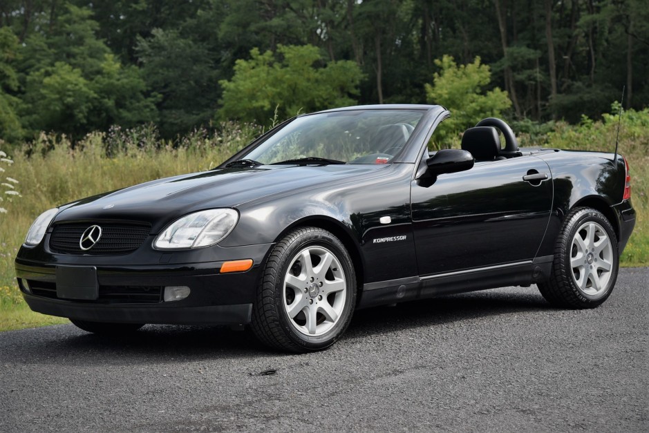 Front angle view of a silver 1999 Mercedes-Benz SLK230 parked outdoors, highlighting its sleek design and iconic Mercedes grille.