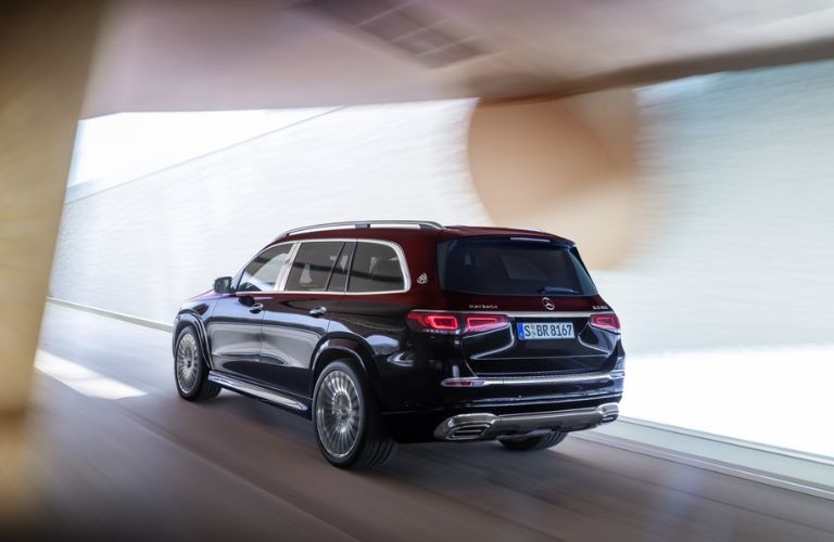 Side view of a luxurious 2021 Mercedes-Benz GLS Maybach SUV in silver color, parked outdoors showcasing its elegant design and spaciousness.