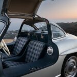 Front three quarter view of a silver 1955 Mercedes-Benz 300 SL Alloy Gullwing showcasing its iconic gullwing doors and sleek design.