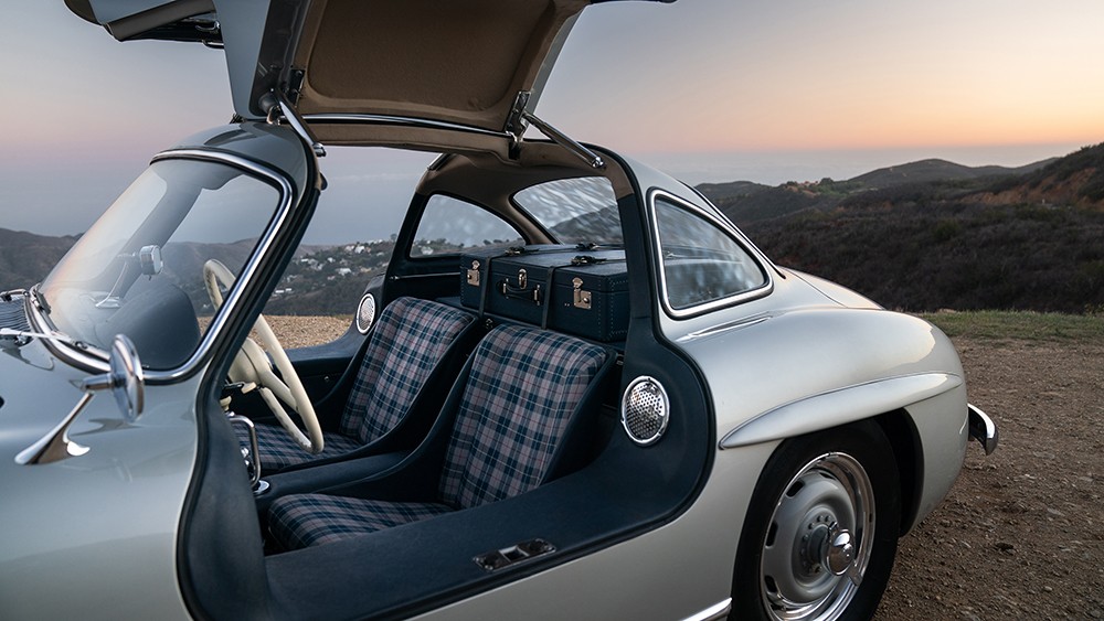 Front three quarter view of a silver 1955 Mercedes-Benz 300 SL Alloy Gullwing showcasing its iconic gullwing doors and sleek design.