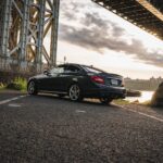 Front view of a Steel Grey Metallic 2013 Mercedes C63 AMG Coupe, showcasing its chrome grille and aggressive stance.