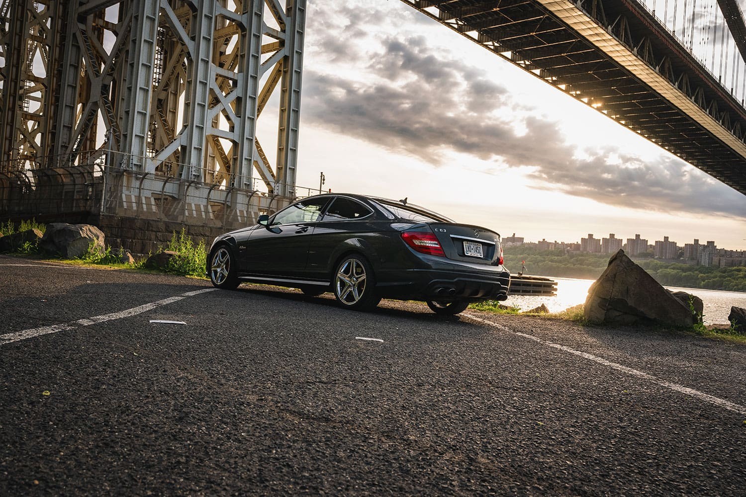 Front view of a Steel Grey Metallic 2013 Mercedes C63 AMG Coupe, showcasing its chrome grille and aggressive stance.