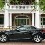 Side-by-side comparison of a silver Audi TT Roadster and a black 2006 Mercedes Benz SLK, highlighting the transition from one roadster to another.