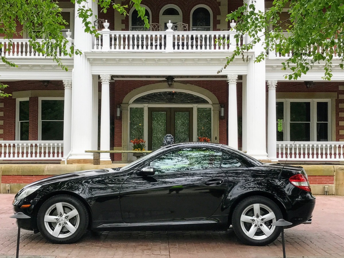 Side-by-side comparison of a silver Audi TT Roadster and a black 2006 Mercedes Benz SLK, highlighting the transition from one roadster to another.