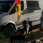 Dodge Sprinter van parked outdoors, showcasing the Dodge logo on the front grille, ideal for van life and camping adventures, in a comparison of Dodge versus Mercedes Sprinter vans.