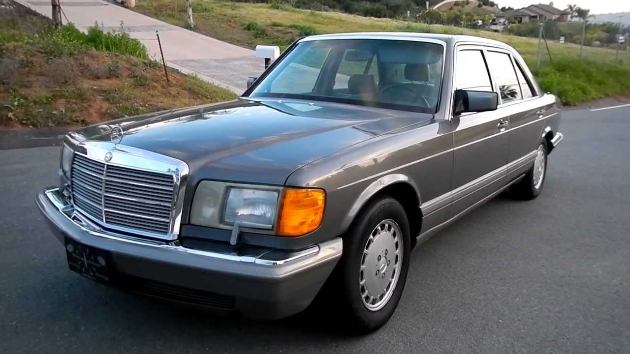 Anthracite grey 1986 Mercedes-Benz 560SEL parked on a paved surface, showcasing its classic sedan profile.