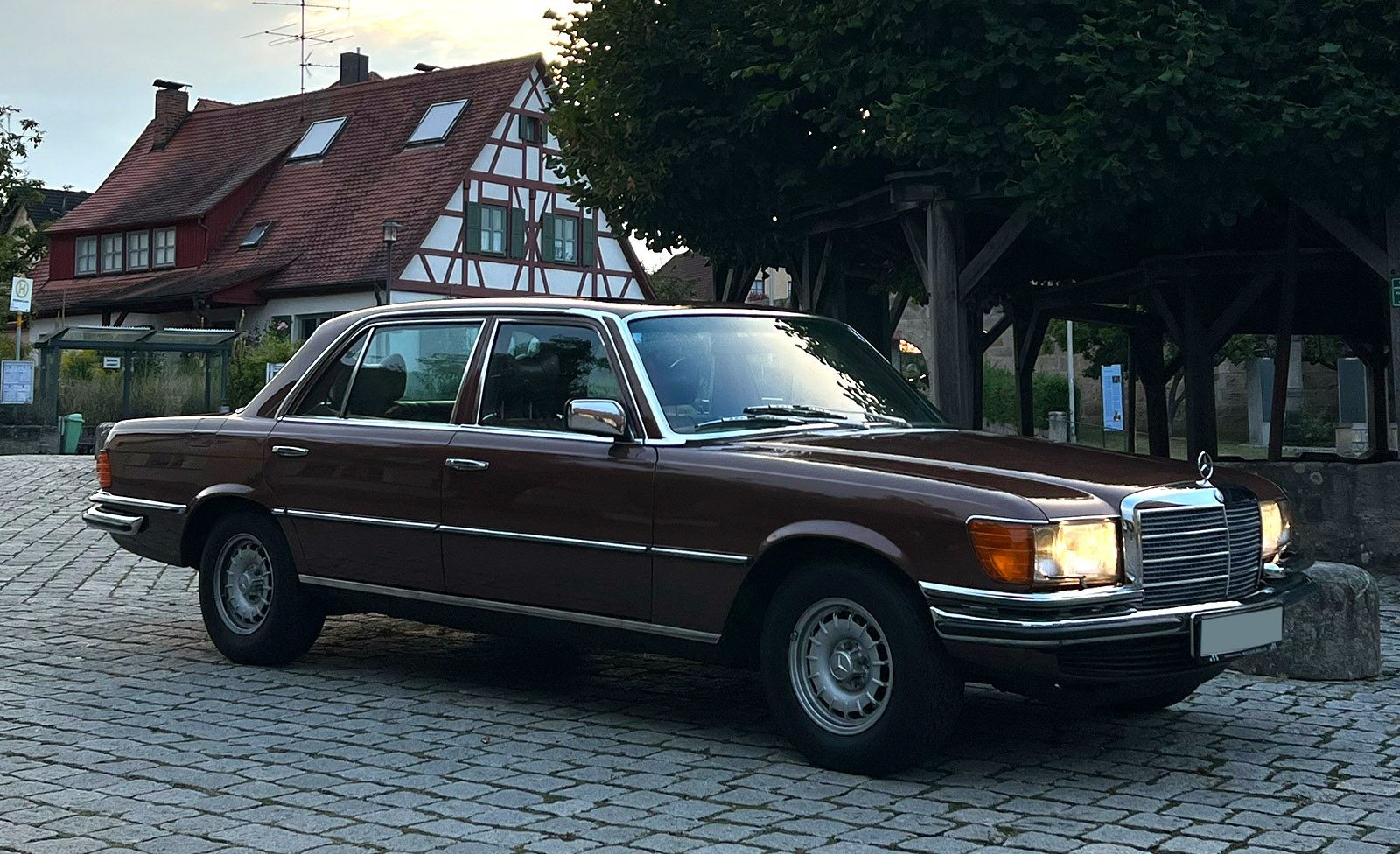 Front profile of a silver Mercedes 450 SEL 6.9 showcasing its iconic grille and headlights