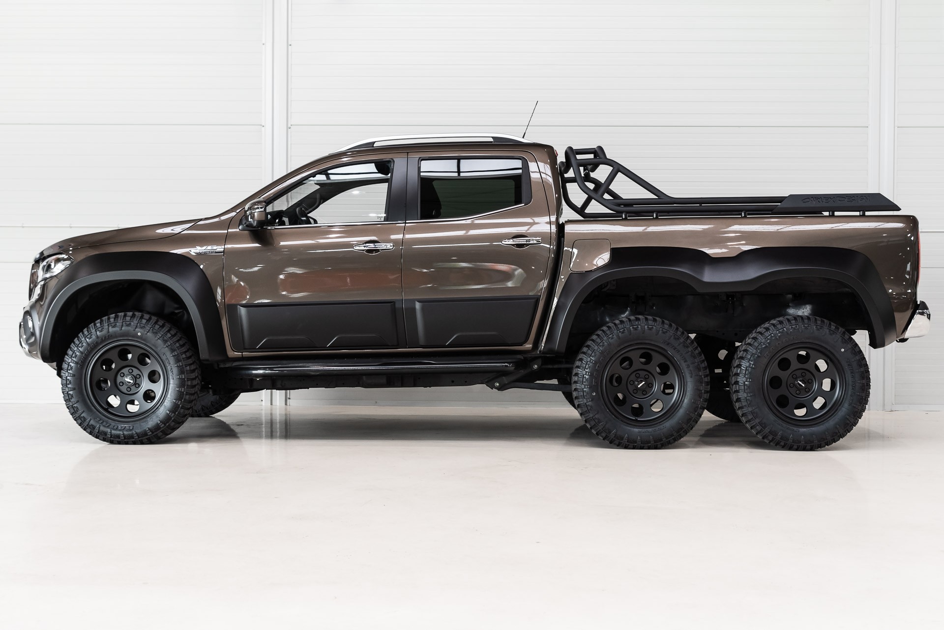 Front quarter view of the six-wheeled Mercedes X-Class showcasing its Panamericana grille and flared wheel arches.