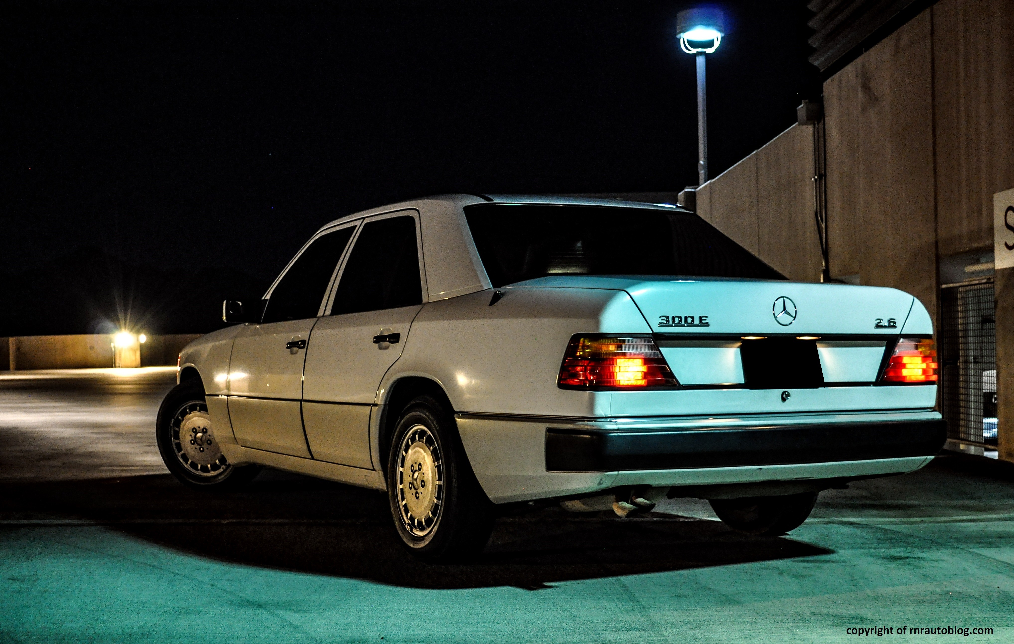 Front quarter view of a silver 1990 Mercedes 300E showcasing its classic design and iconic grille.