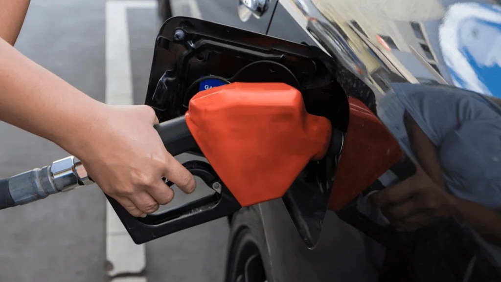 Fuel pump nozzle filling a car tank with gasoline