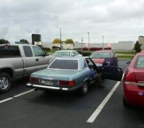 Front three quarter view of a 1979 Mercedes Benz 450SL hardtop in silver parked outdoors