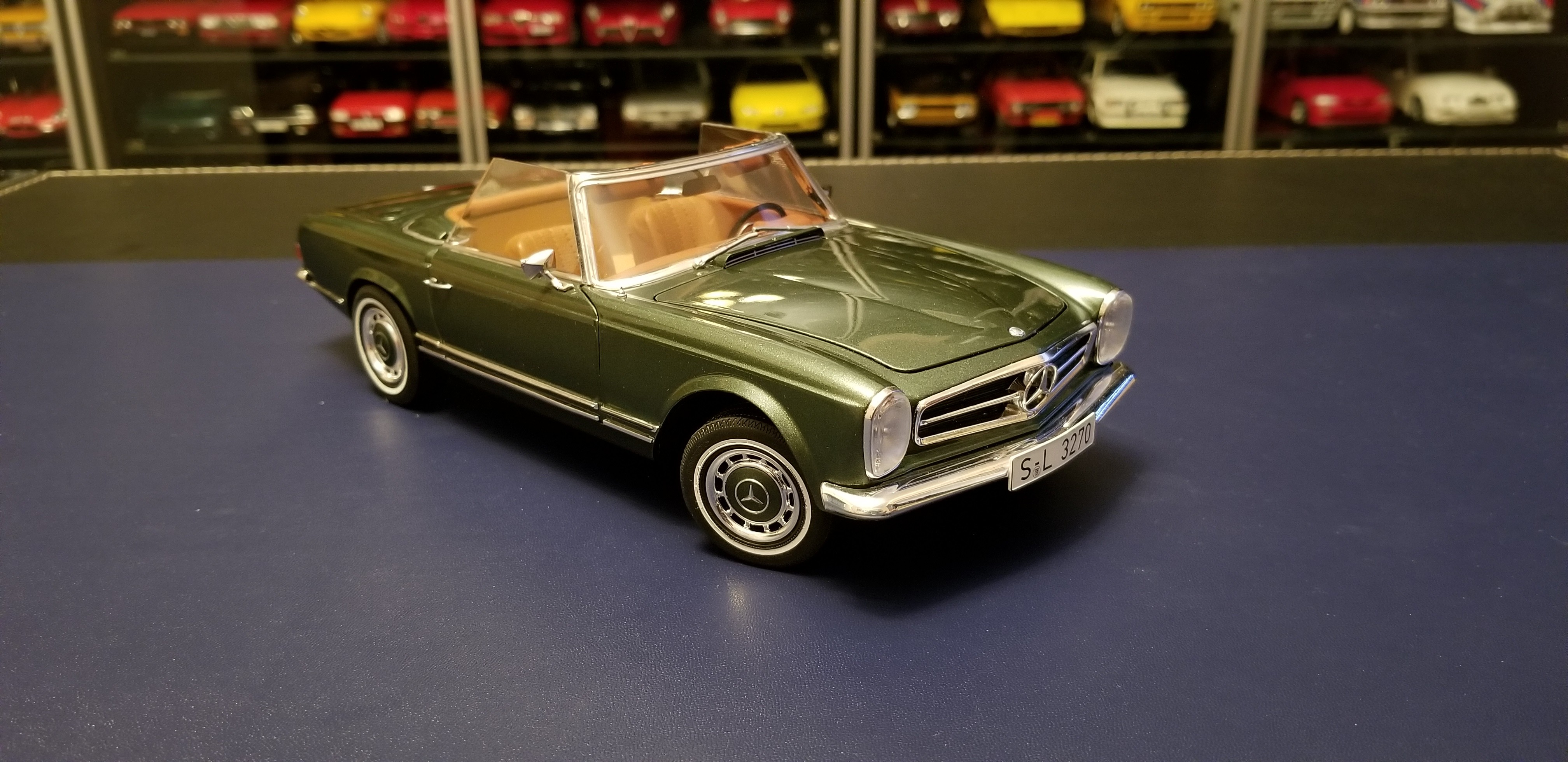 Front three quarter view of the Moosgrun metallic Schuco 1968 Mercedes 280SL model car showcasing its detailed grille and headlights.