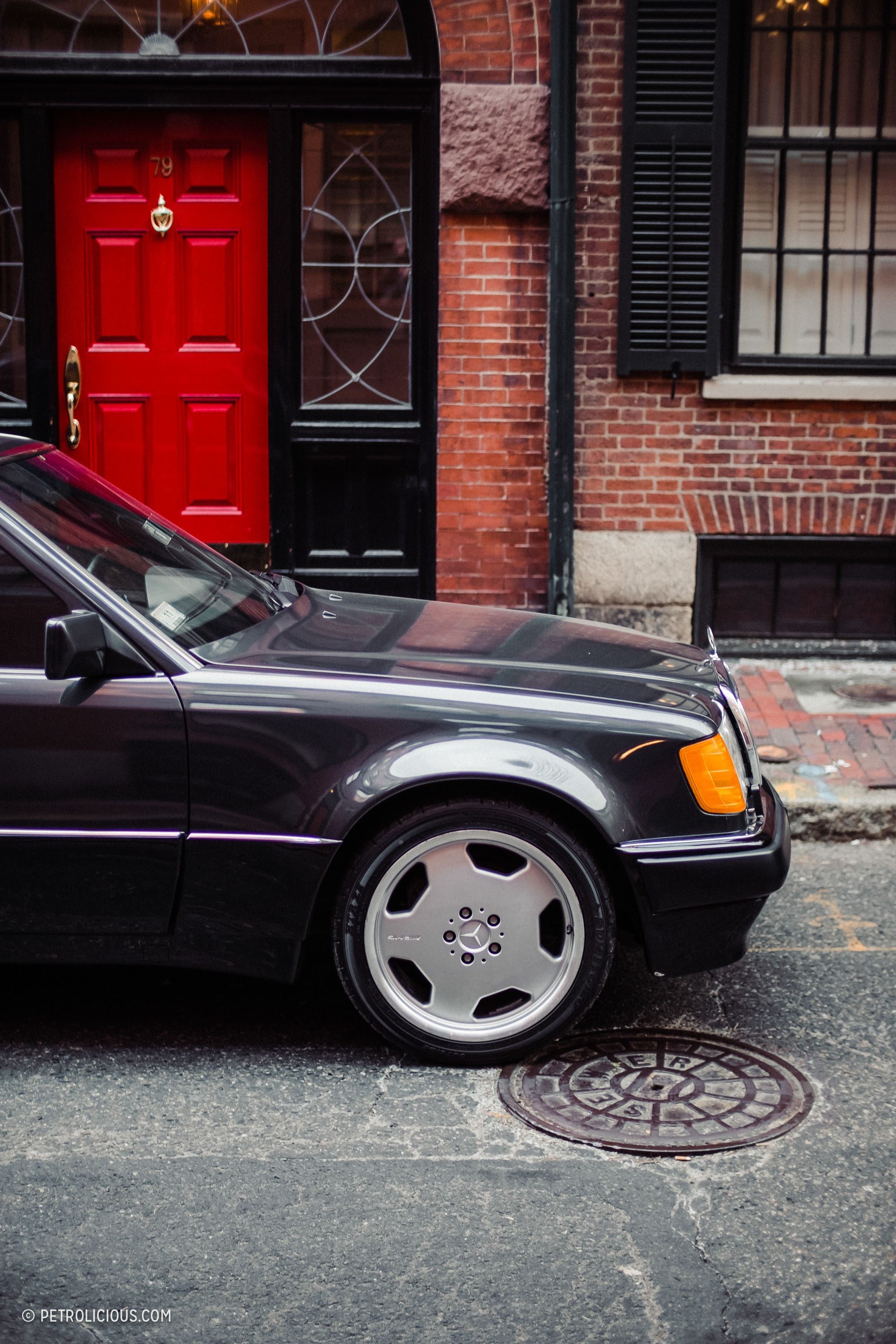 Front three quarter view of a black 1992 Mercedes 500E showcasing its classic design and subtle fender flares.